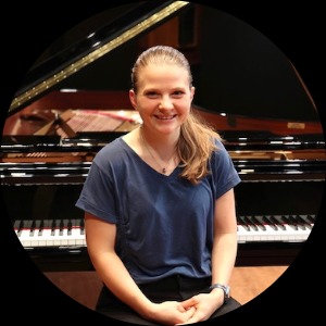 Olivia Colomaio, a white woman seated at a piano